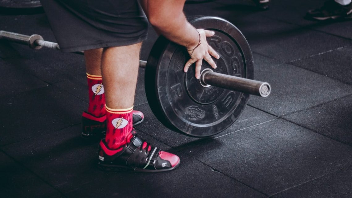 person arranging barbell plate